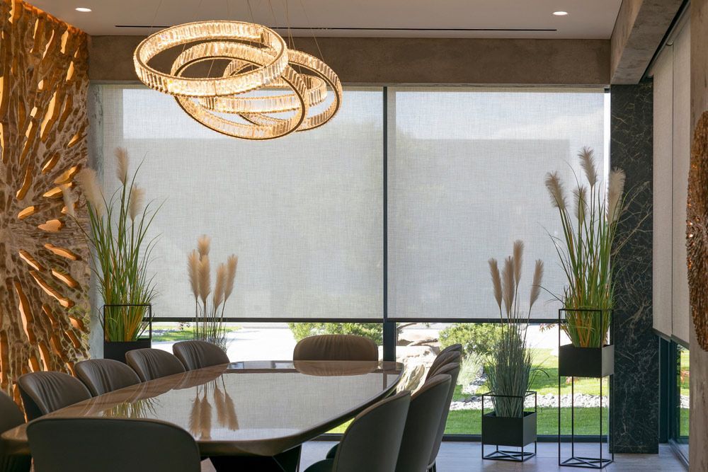 A Dining Room With A Long Table And Chairs And A Big Window That Has Blinds — Queanbeyan Carpets in Woden, NSW