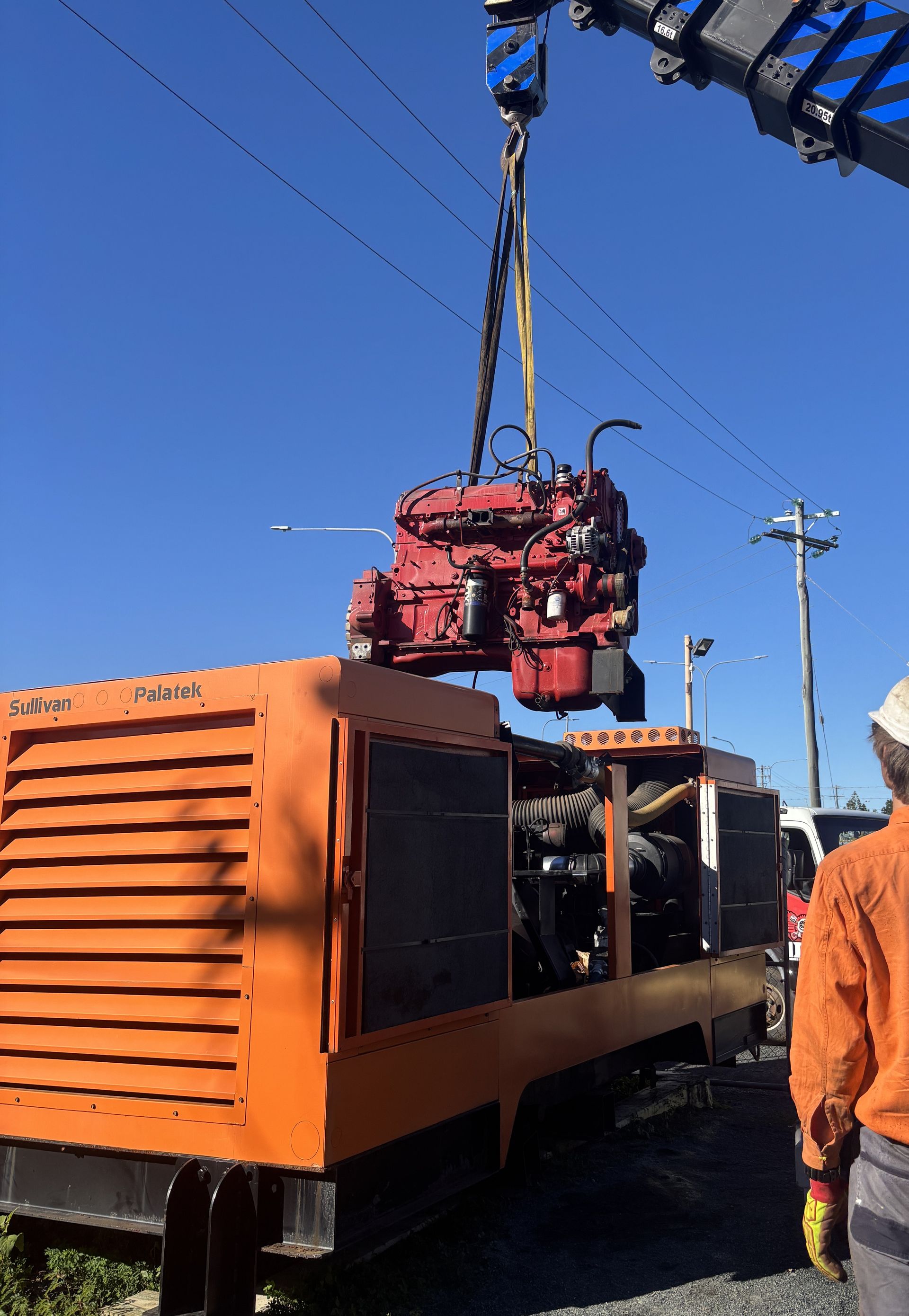 A Crane Lifting a Red Engine From an Orange Generator Unit Against a Blue Sky — Joy Hire Compressor Hire & Maintenance in Paget, QLD