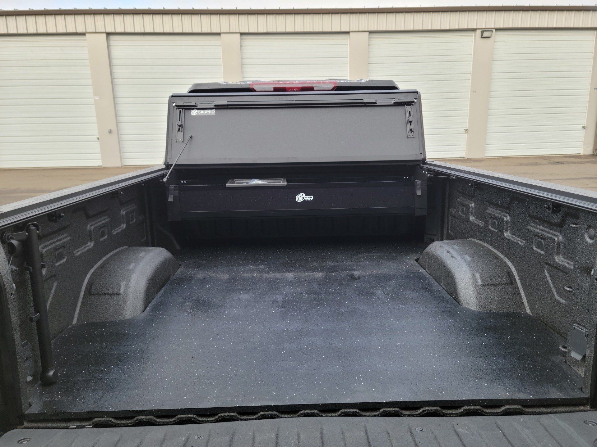 The back of a truck is shown with the bed open.
