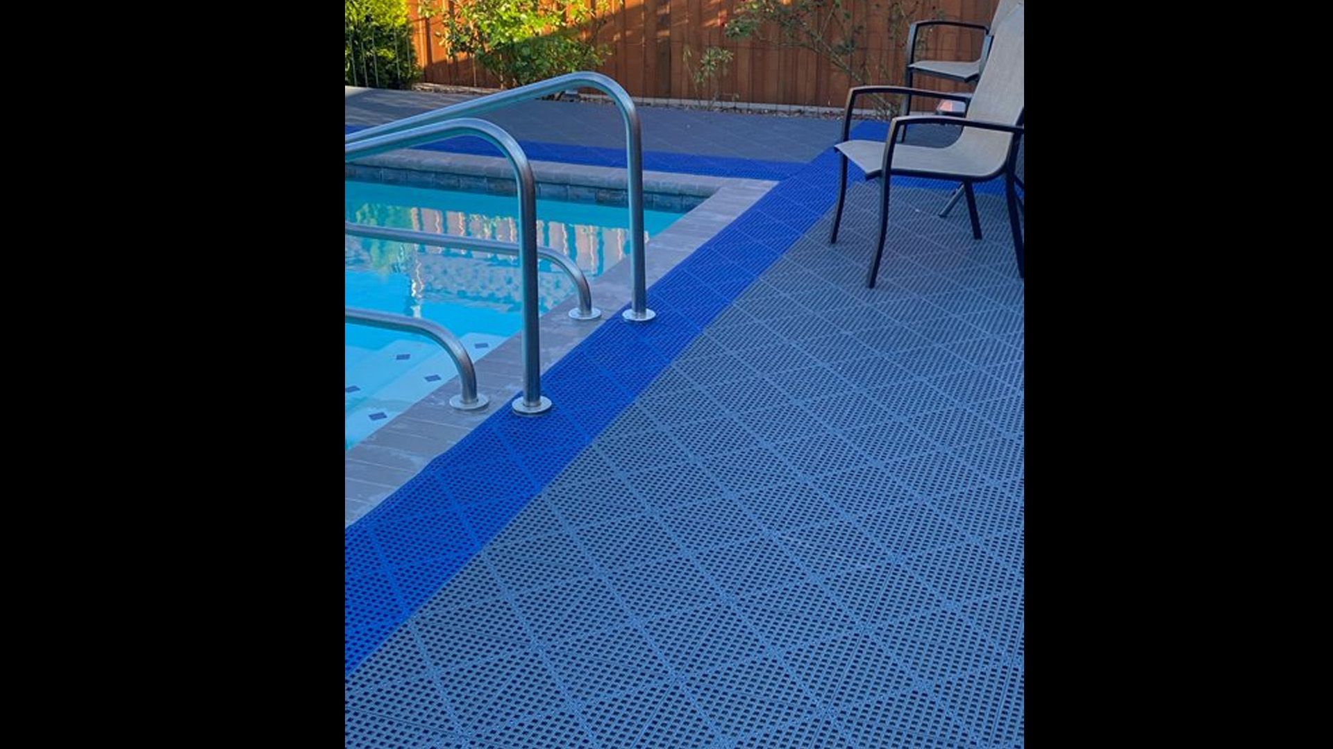 A swimming pool with blue tiles on the floor and stairs leading to it.