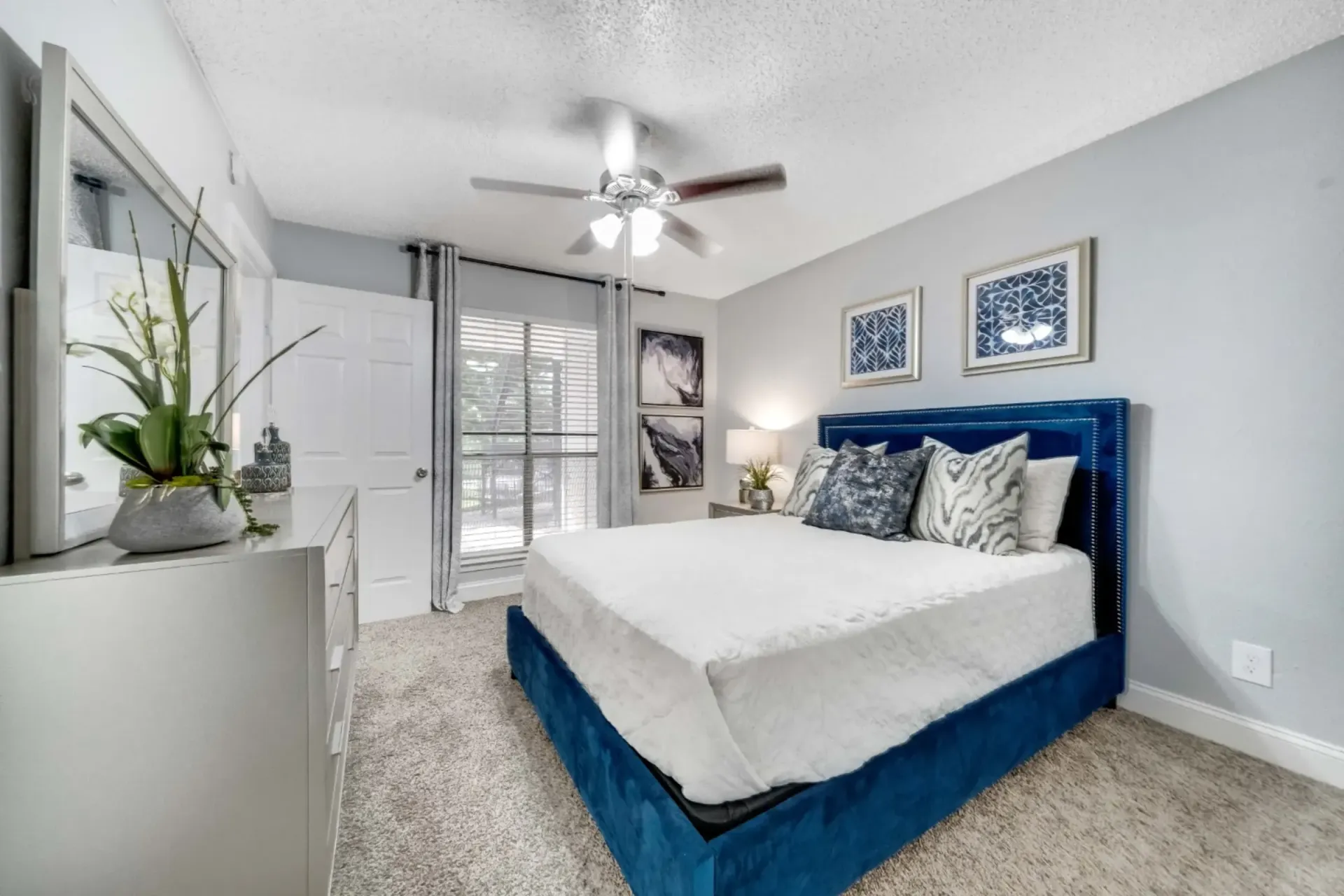 A bedroom with a large bed and a ceiling fan