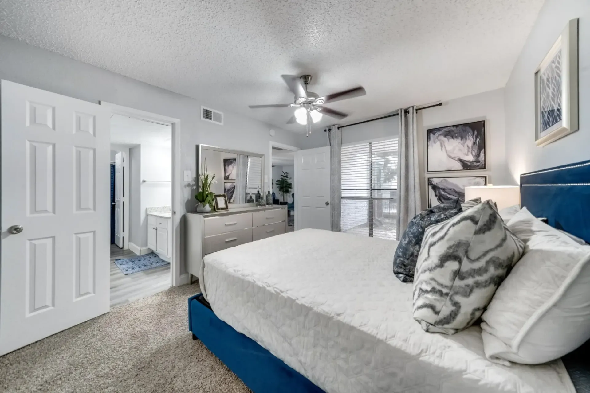 A bedroom with a king size bed and a ceiling fan.
