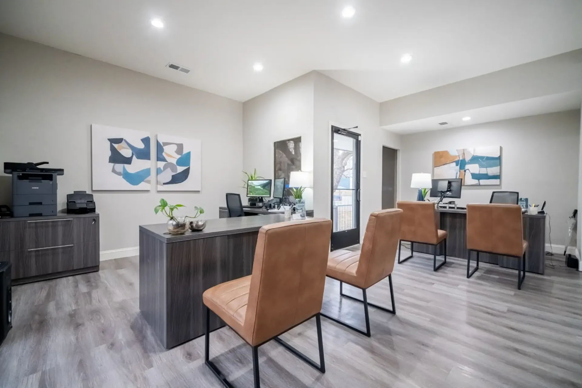 A room with a desk and chairs in it.