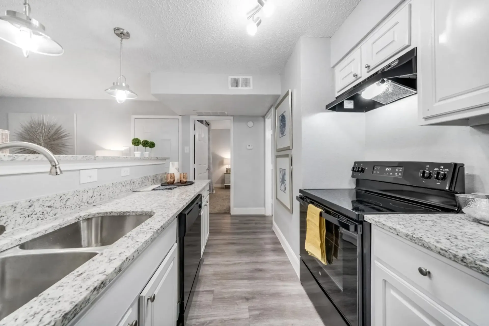 A kitchen with a stove , sink , and dishwasher.
