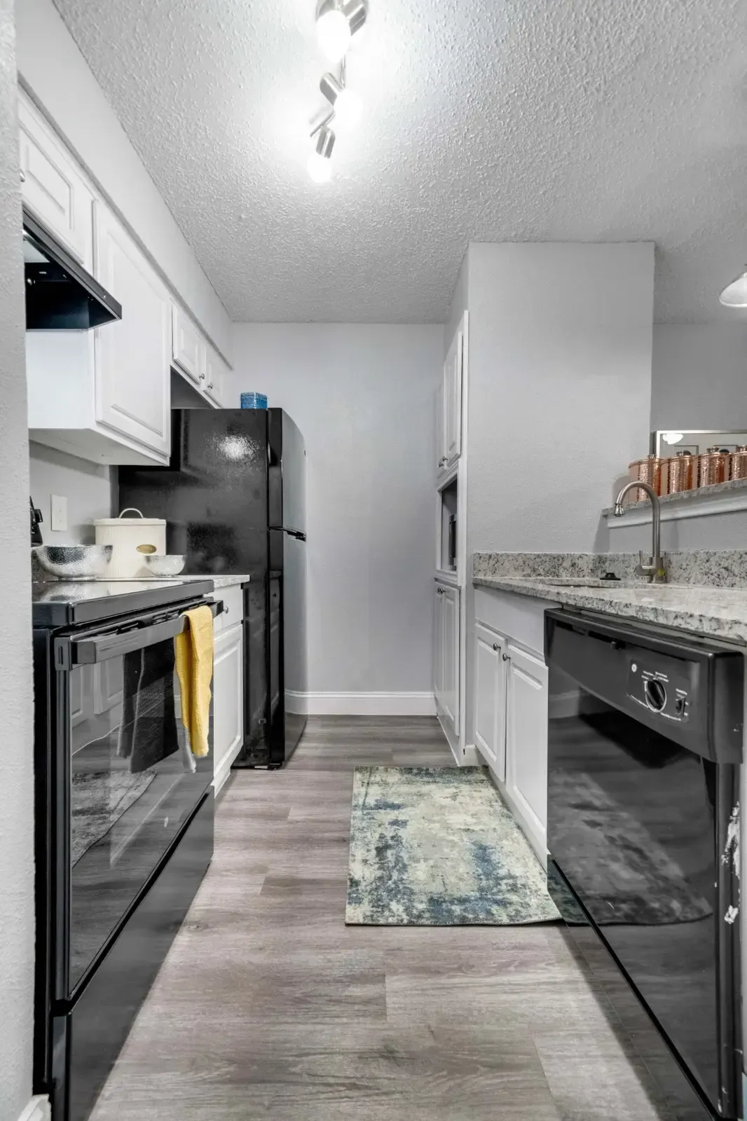 A kitchen with a refrigerator , stove , dishwasher , and sink.