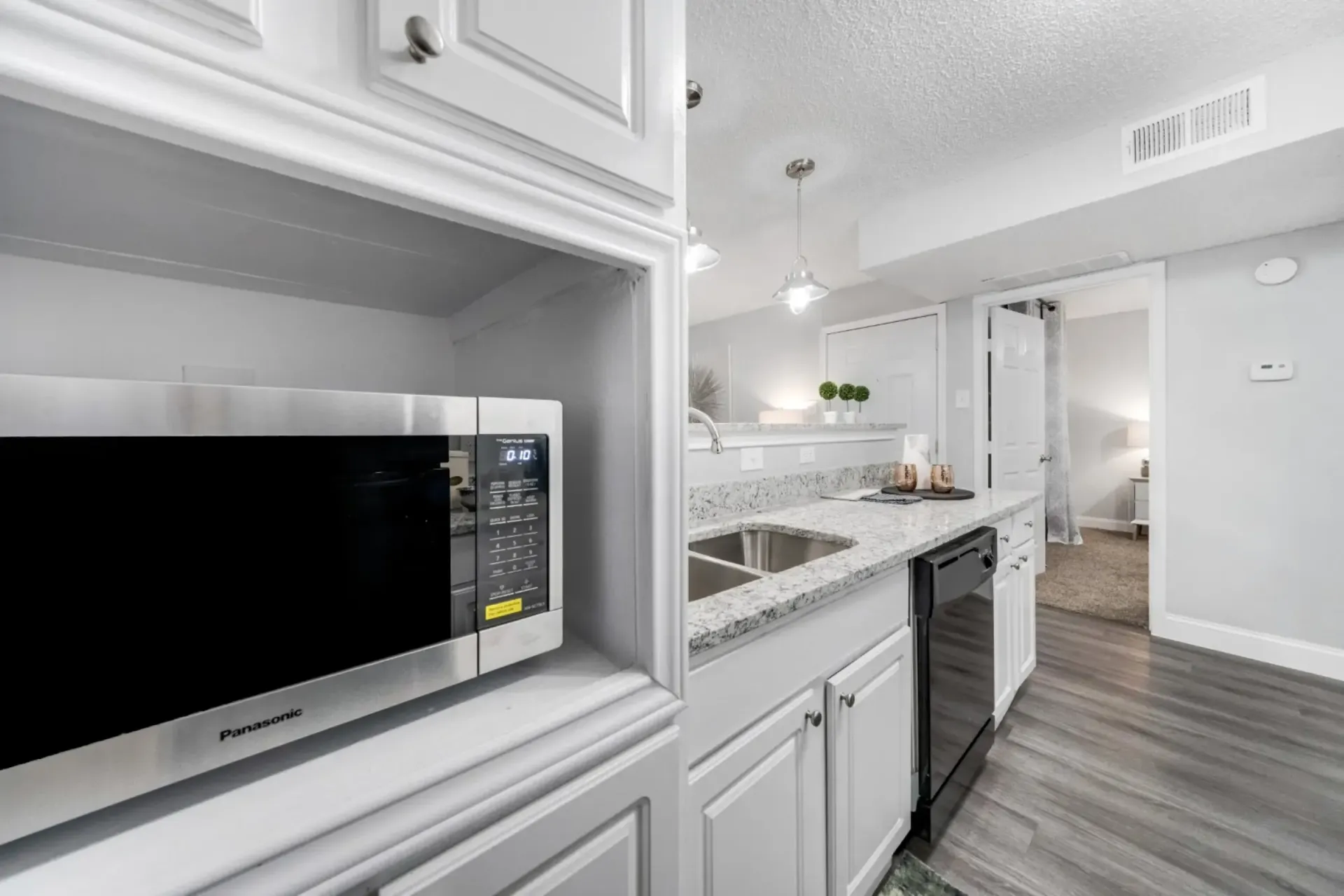 A kitchen with a microwave , sink , and dishwasher.