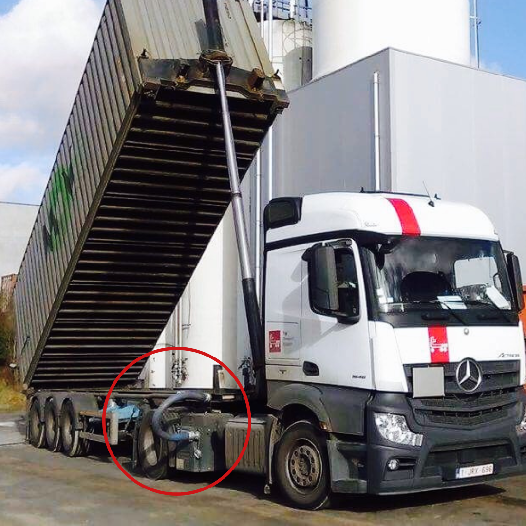 Een witte Mercedes-kipper met een verhoogde container; een zwarte slang is omcirkeld.