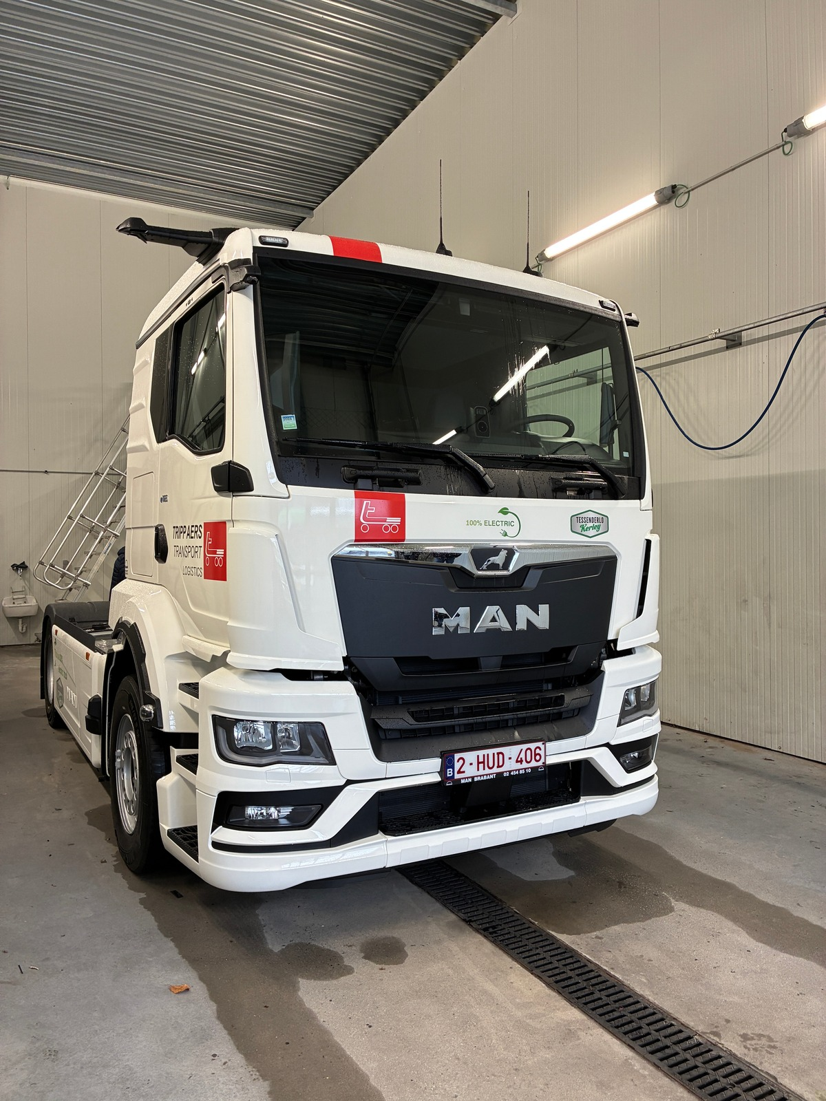 Witte etruck MAN-vrachtwagen geparkeerd in een garage. Zwarte grille met redline