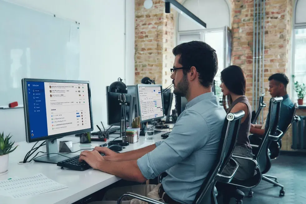 People working at computers in an office setting.