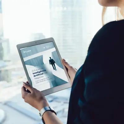 Woman holding a tablet with a cover titled “Artificial Intelligence in Negotiation.”
