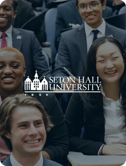 Students in suits smiling at Seton Hall University.