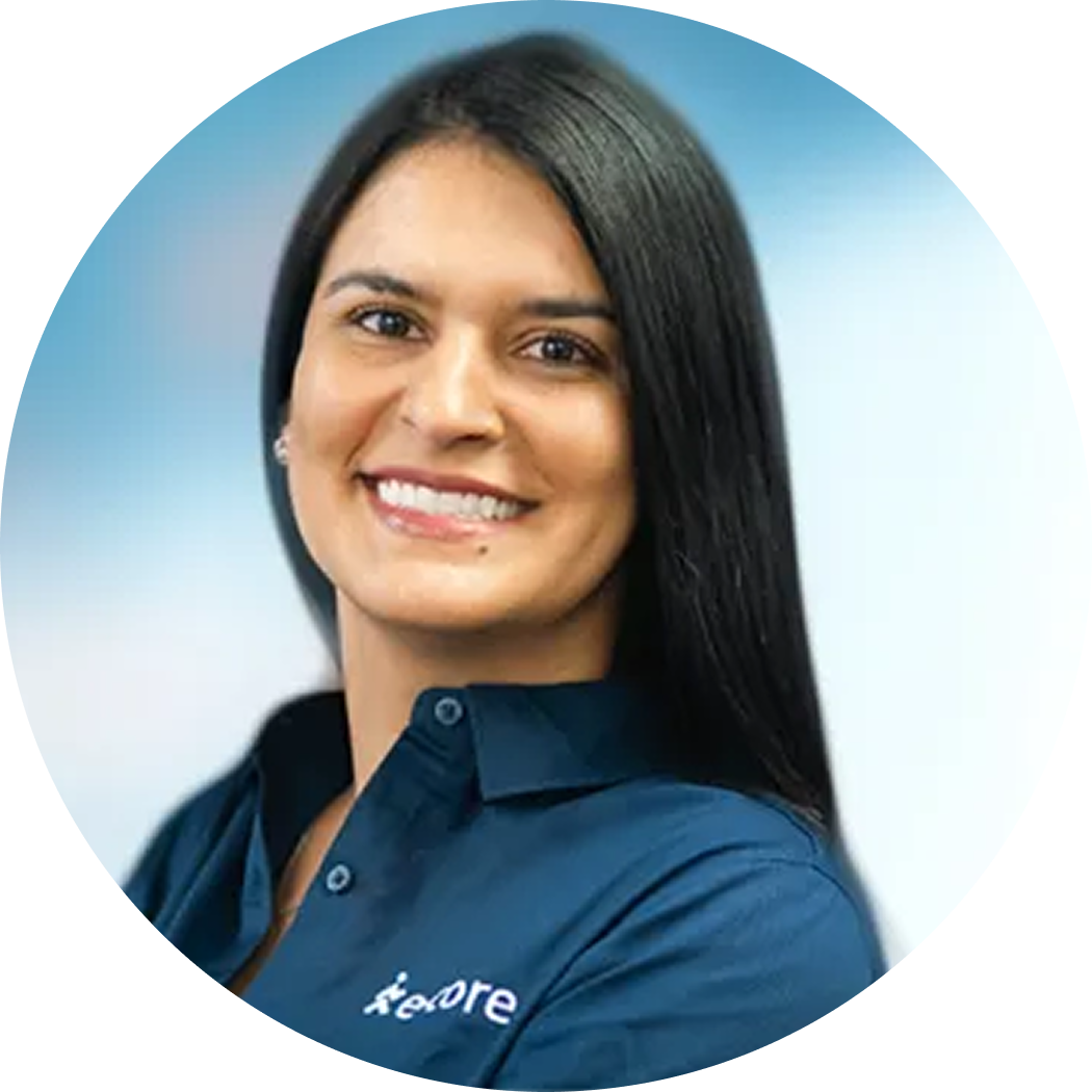 Smiling woman in a blue shirt with a logo, posed against a light blue background.