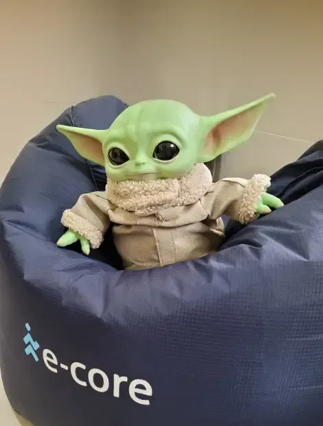 Baby Yoda doll in a blue beanbag chair with 