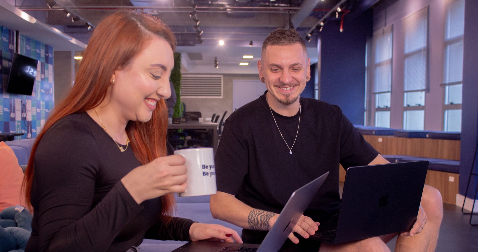 dois colegas de trabalho da e-Core conversando e olhando o computador
