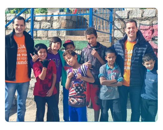 Colaboradores e-Core Um grupo de pessoas posando para uma foto com um homem vestindo uma camisa laranja que diz