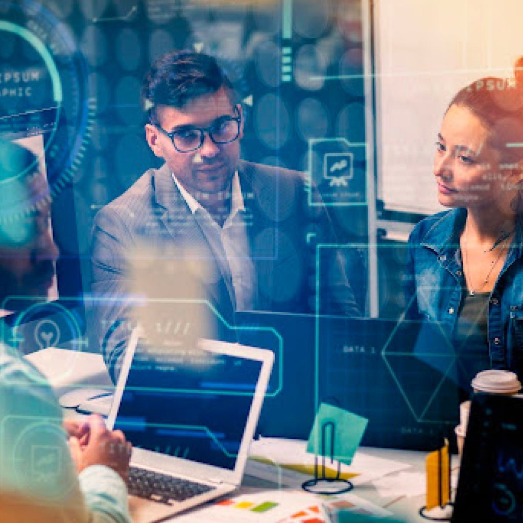 People in business attire at a table with laptops, discussing a project, overlaid with digital graphics.