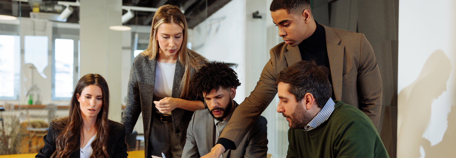 Business colleagues gathered in an office, reviewing documents.