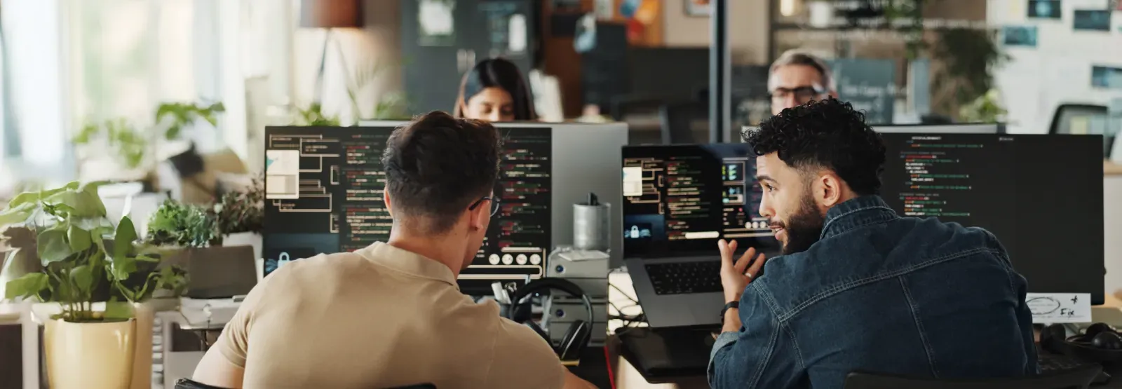 Two people working at computers in an office setting.