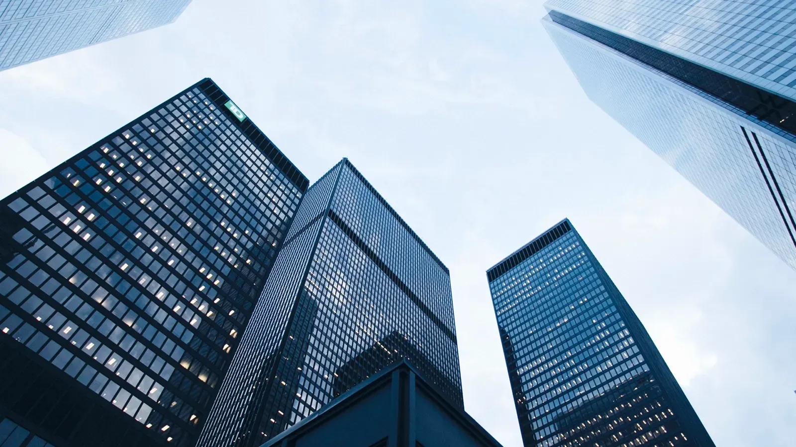 Looking up at a group of tall buildings with a blue sky in the background.