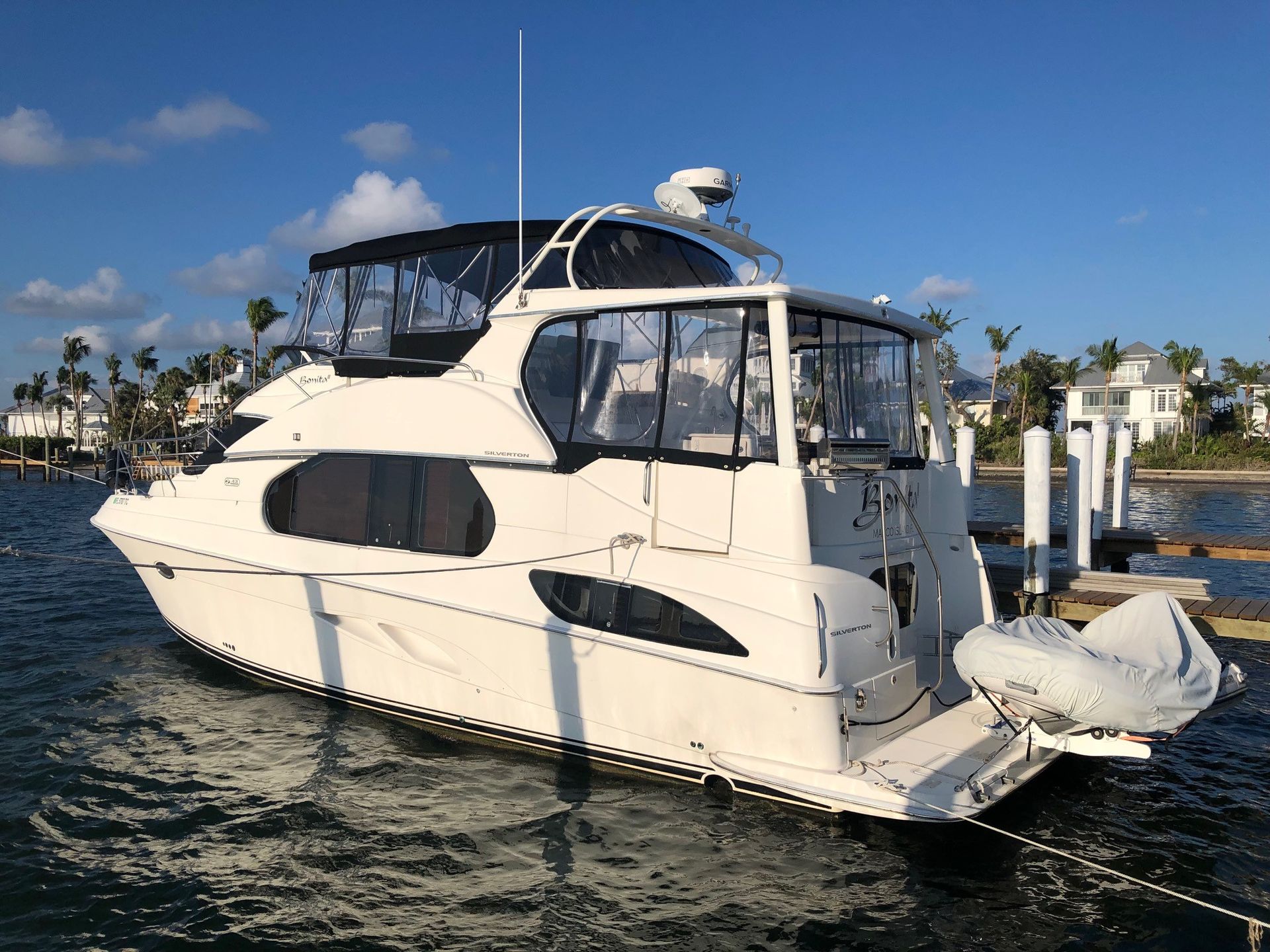 A white yacht is docked at a dock in the water.