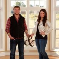 Two people standing in a bright room, holding a large decorative
