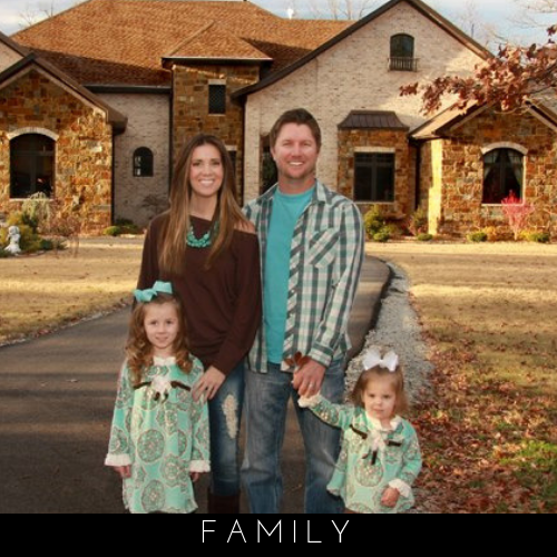 Family of four posing outside a stone-and-brick house in autumn, with “FAMILY” text below.