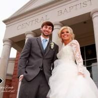 Bride and groom standing outside Central Baptist church in wedding attire