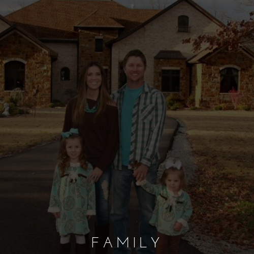 Family of four standing outside a brick house in autumn, with “FAMILY” text at the bottom.