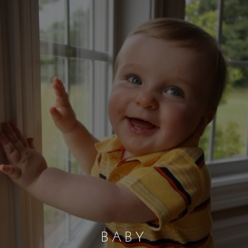 Smiling baby in a yellow shirt touching a window beside a sunny view