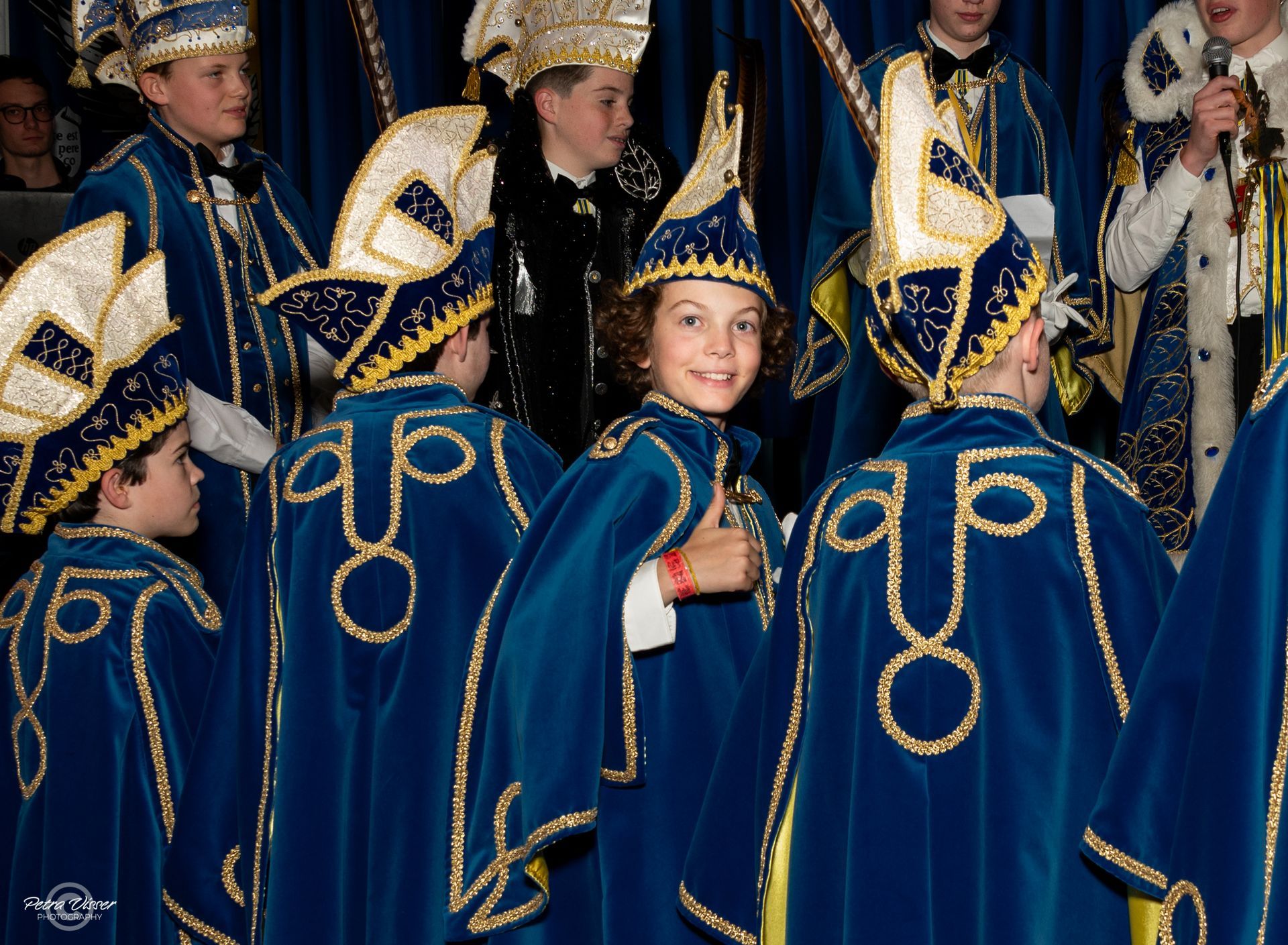 Een groep kinderen gekleed in blauwe en gouden kostuums