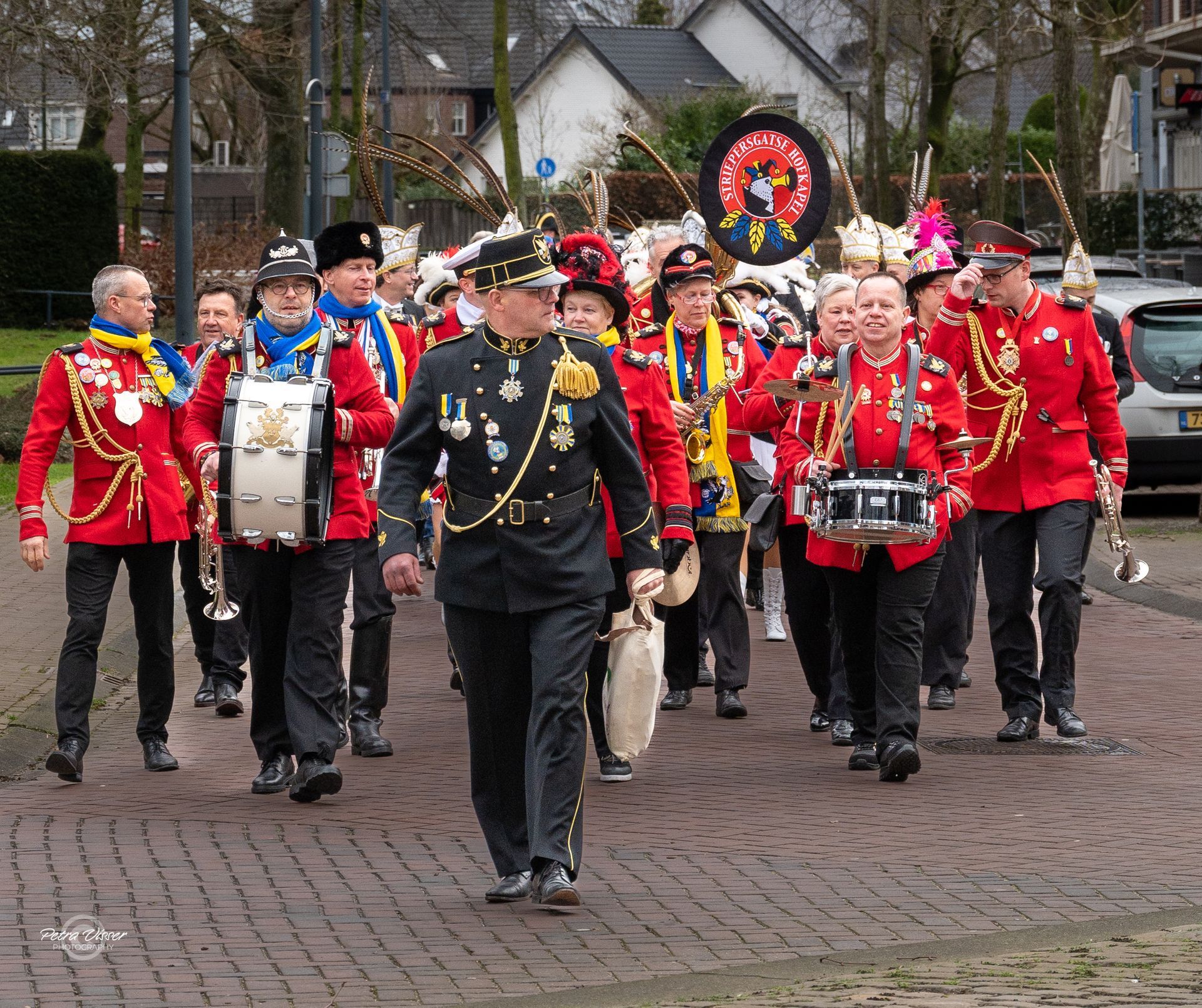Een fanfare marcheert over een stenen weg