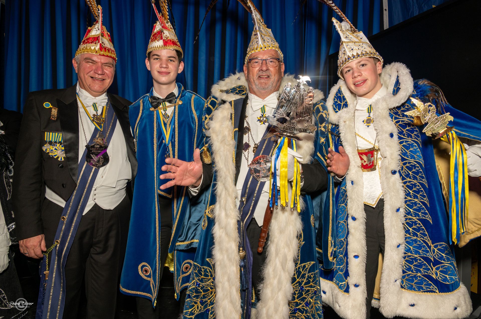 Een groep mannen in blauwe en gouden kostuums poseert voor een foto.