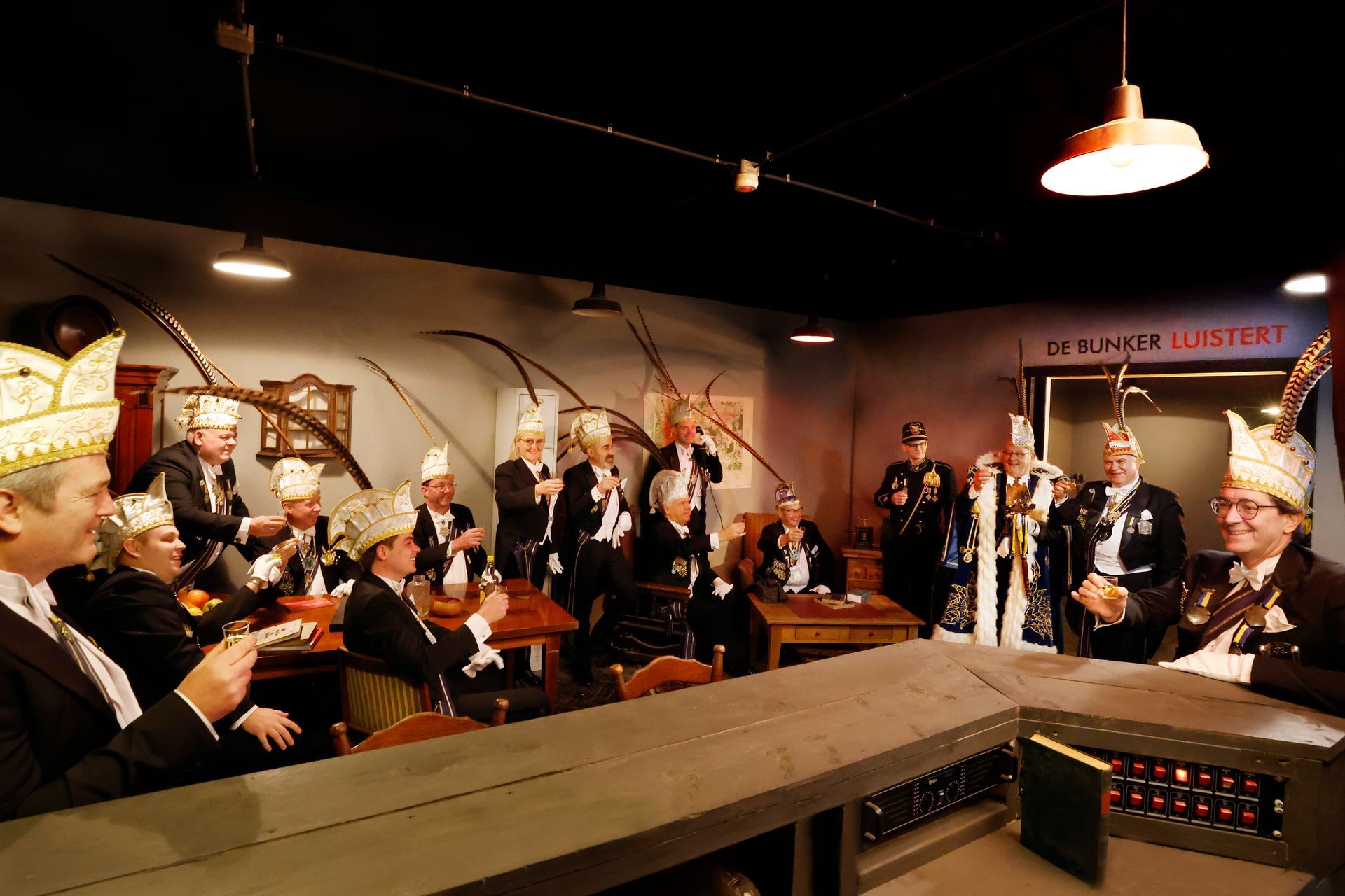 Een groep mensen zit aan tafels in een kamer.