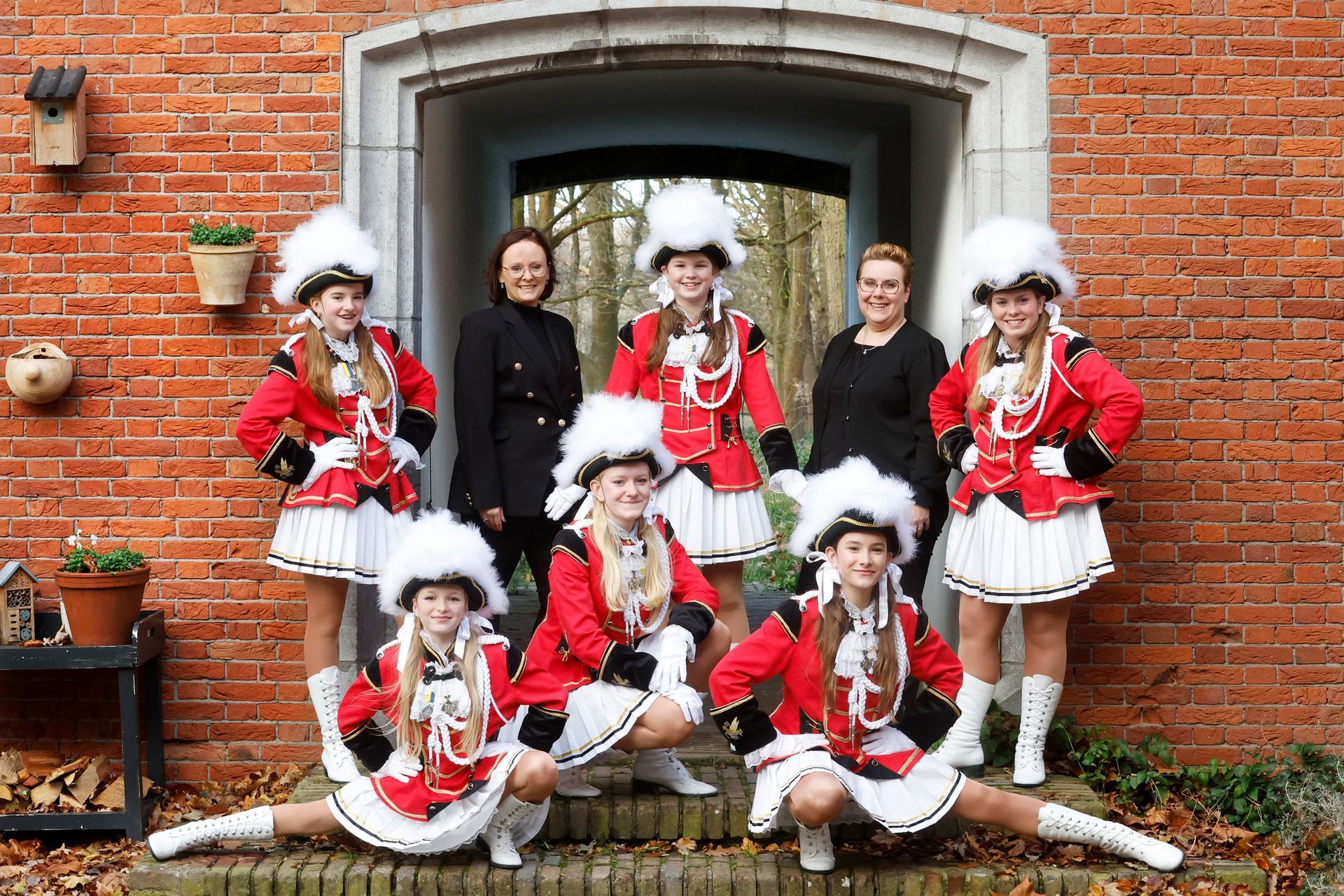 Een groep vrouwen poseert voor een foto voor een bakstenen gebouw.