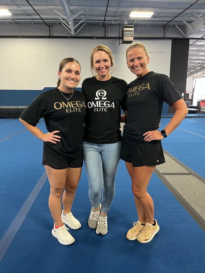 A group of cheerleaders are posing for a picture in a gym.