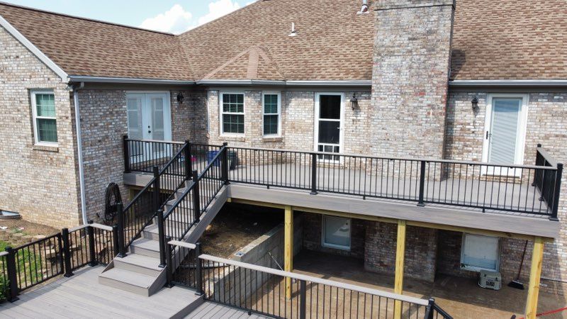 An aerial view of a house with a large deck and stairs leading up to it.