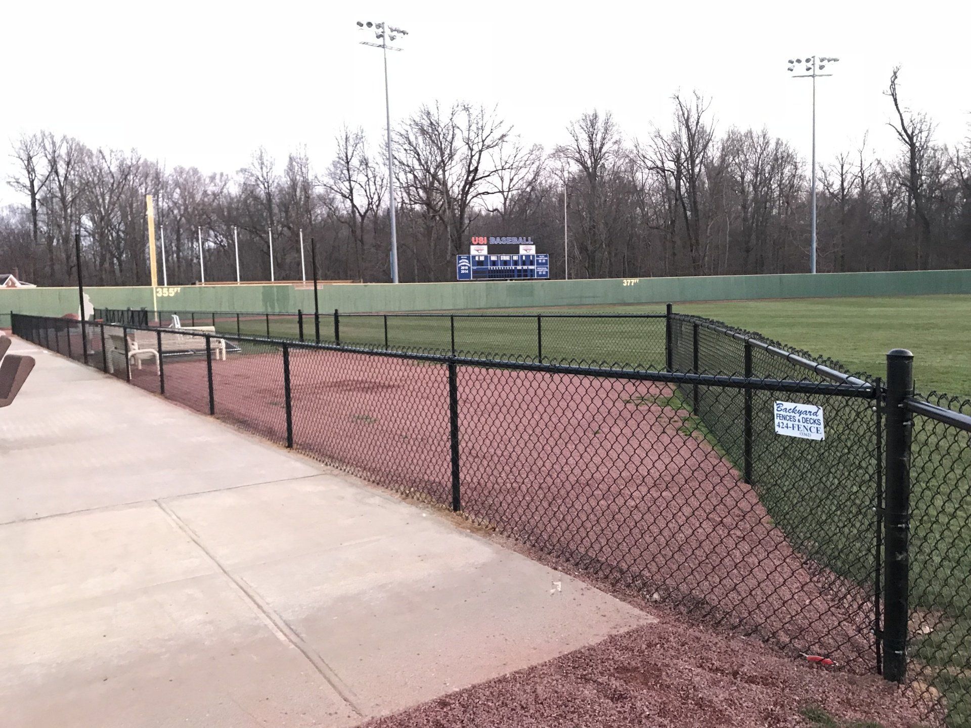 A chain link fence surrounds a baseball field.