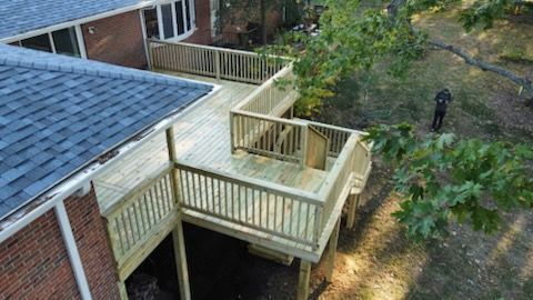 An aerial view of a wooden deck next to a brick house.