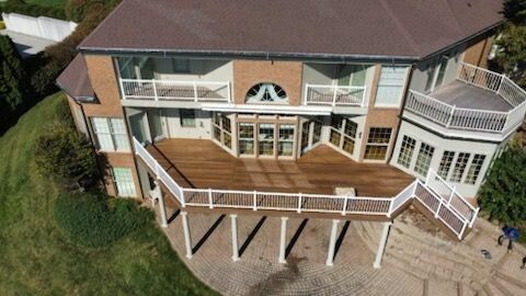 An aerial view of a large house with a large deck.