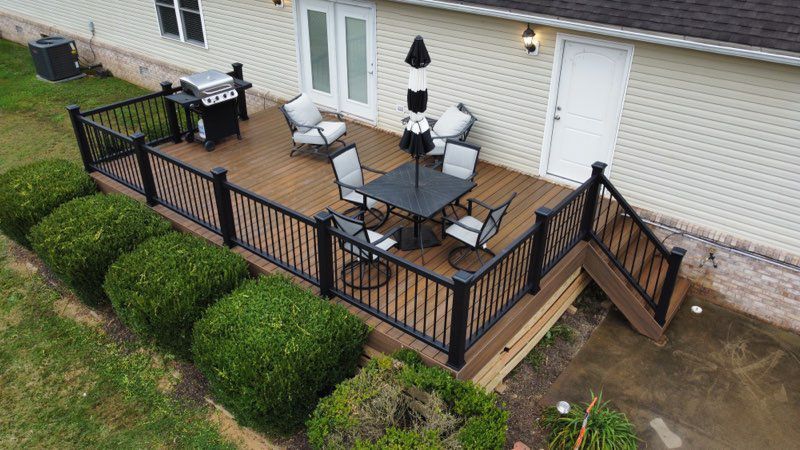 An aerial view of a deck with a table and chairs and a grill.