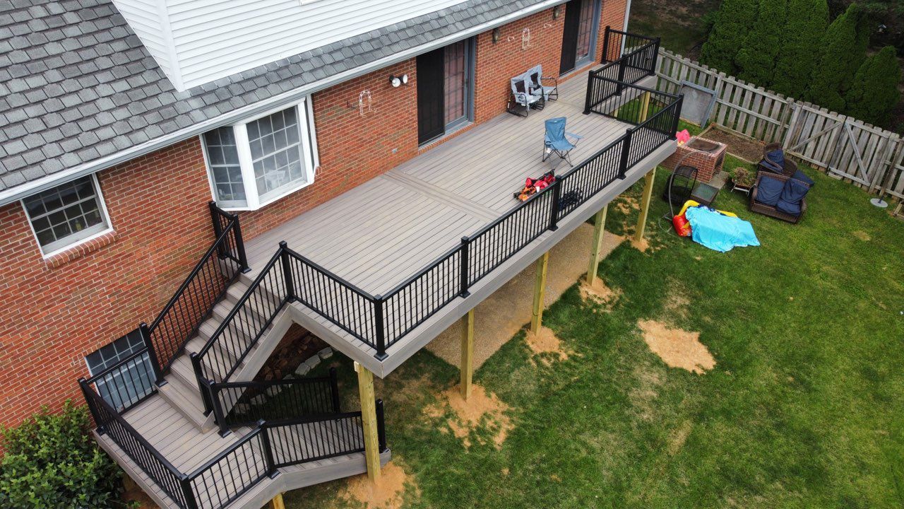 An aerial view of a house with a large deck and stairs.