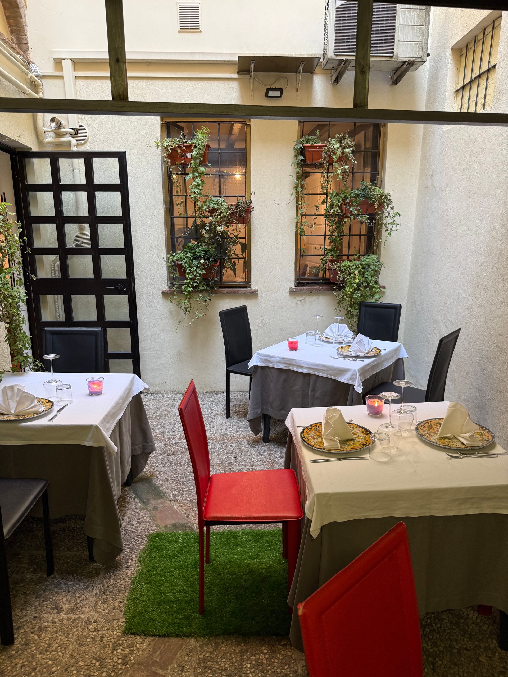 Un ristorante con tavoli e sedie in un cortile
