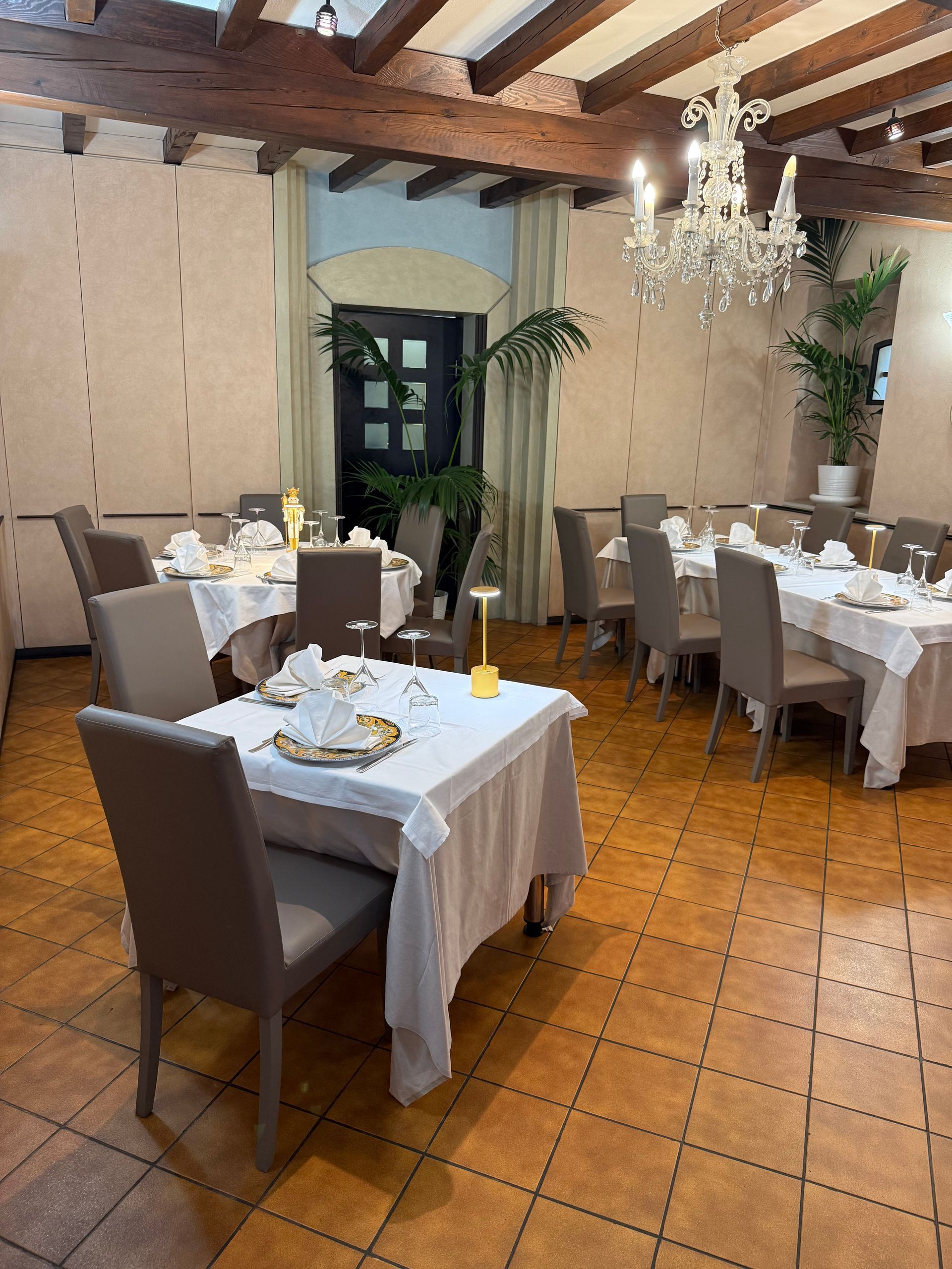 Una grande sala da pranzo con tavoli e sedie e un lampadario