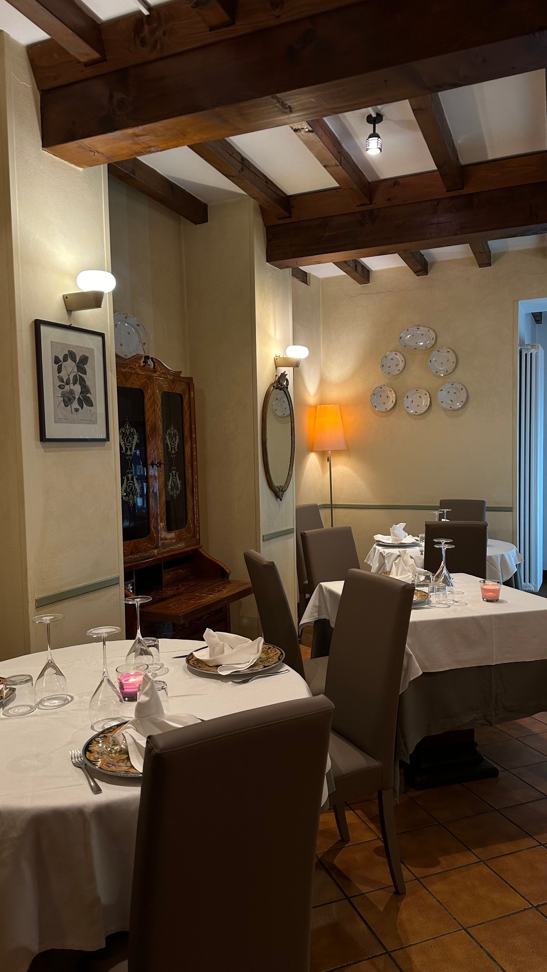 Un ristorante con tavoli, sedie e piatti sul muro.