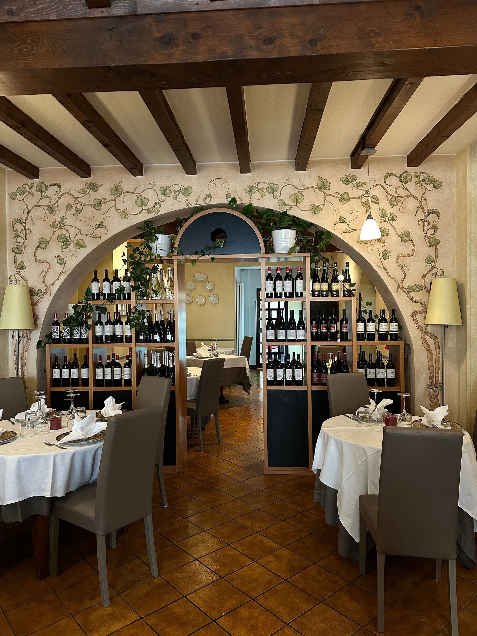 Un ristorante con tavoli, sedie e scaffali pieni di vino
