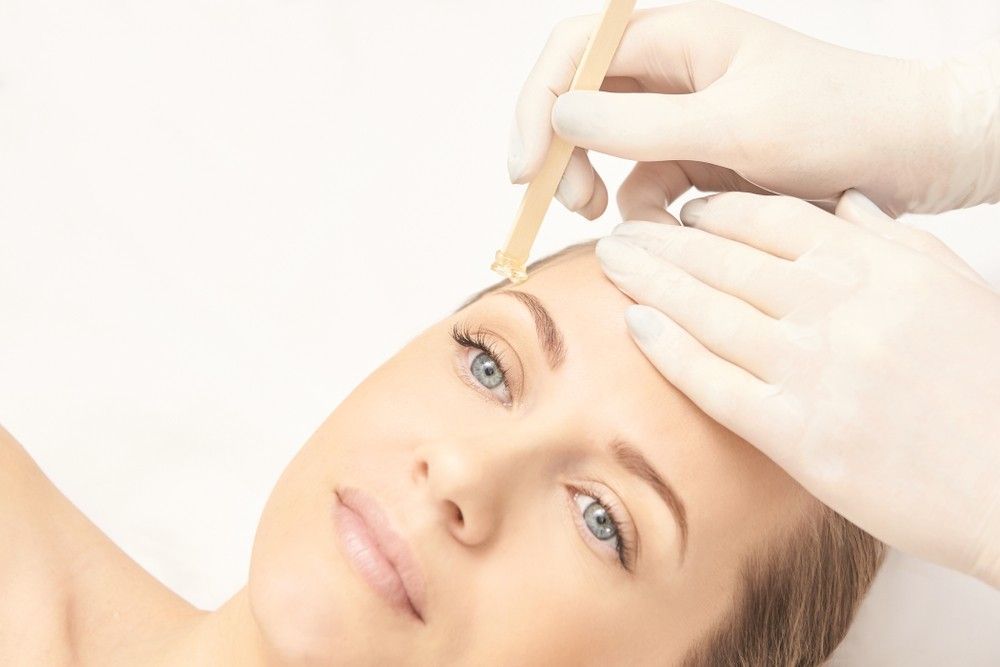 A Woman is Getting Her Eyebrows Waxed in a Beauty Salon — Organic Beauty by Kessie in Yeppoon, QLD