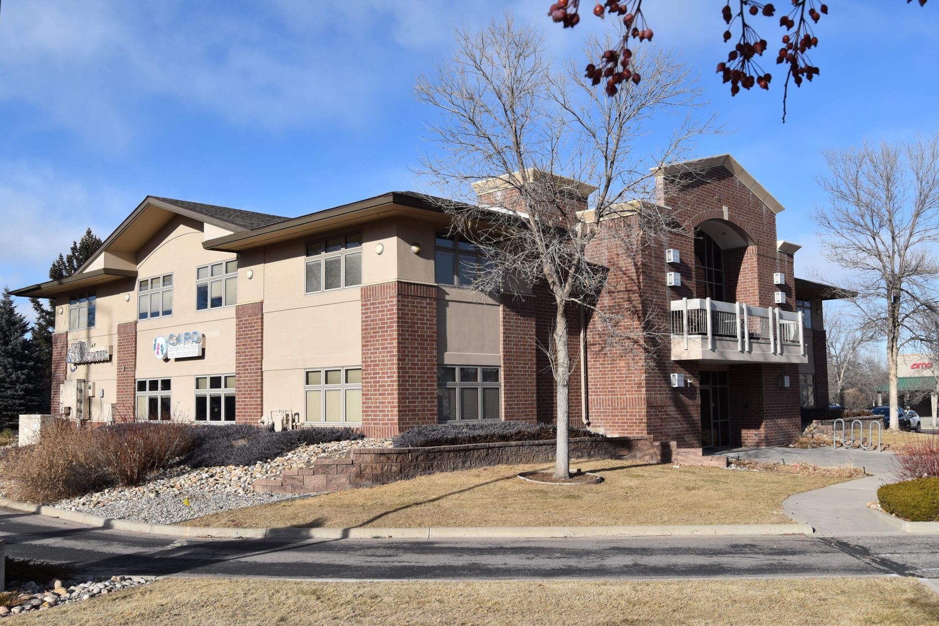 A large brick building with a lot of windows and a tree in front of it.