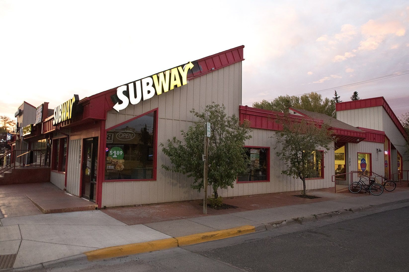 A subway restaurant is located on the corner of a street.