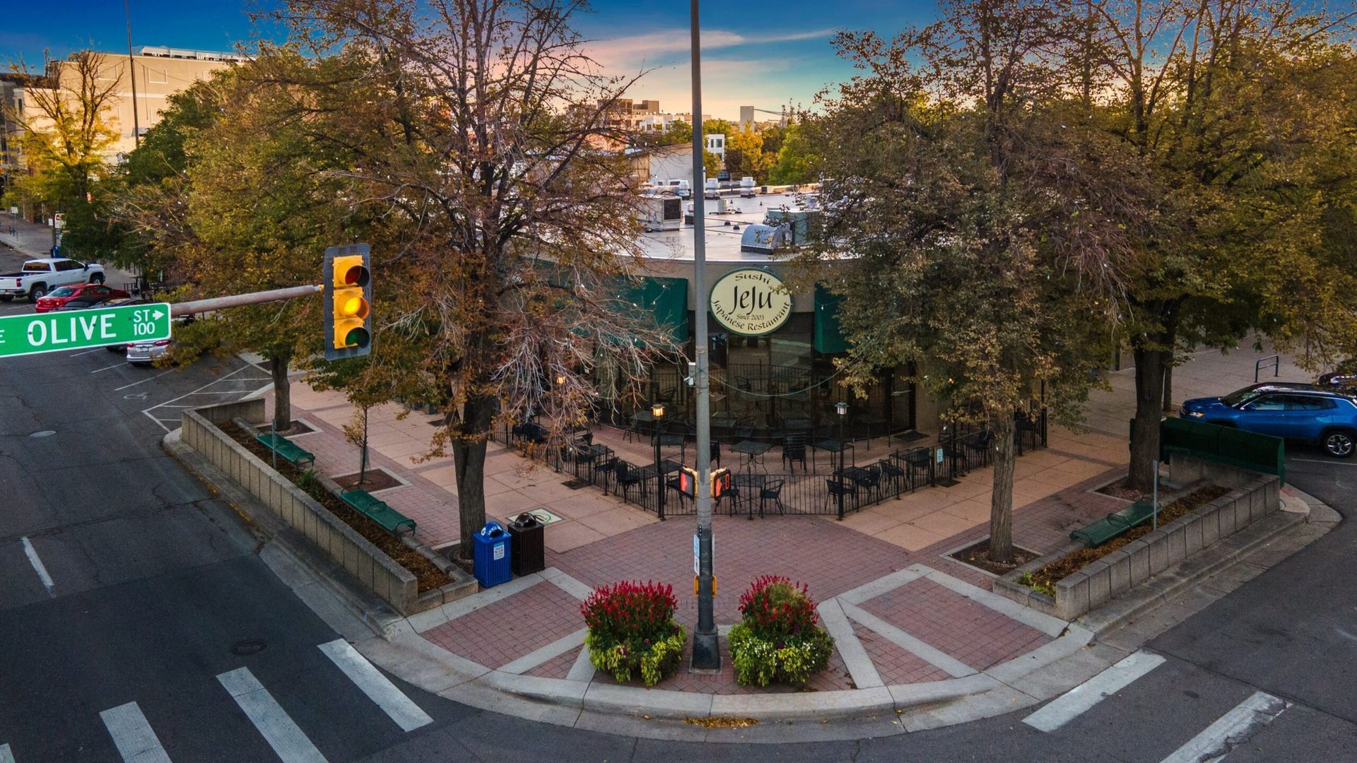 An aerial view of a restaurant on the corner of a city street.