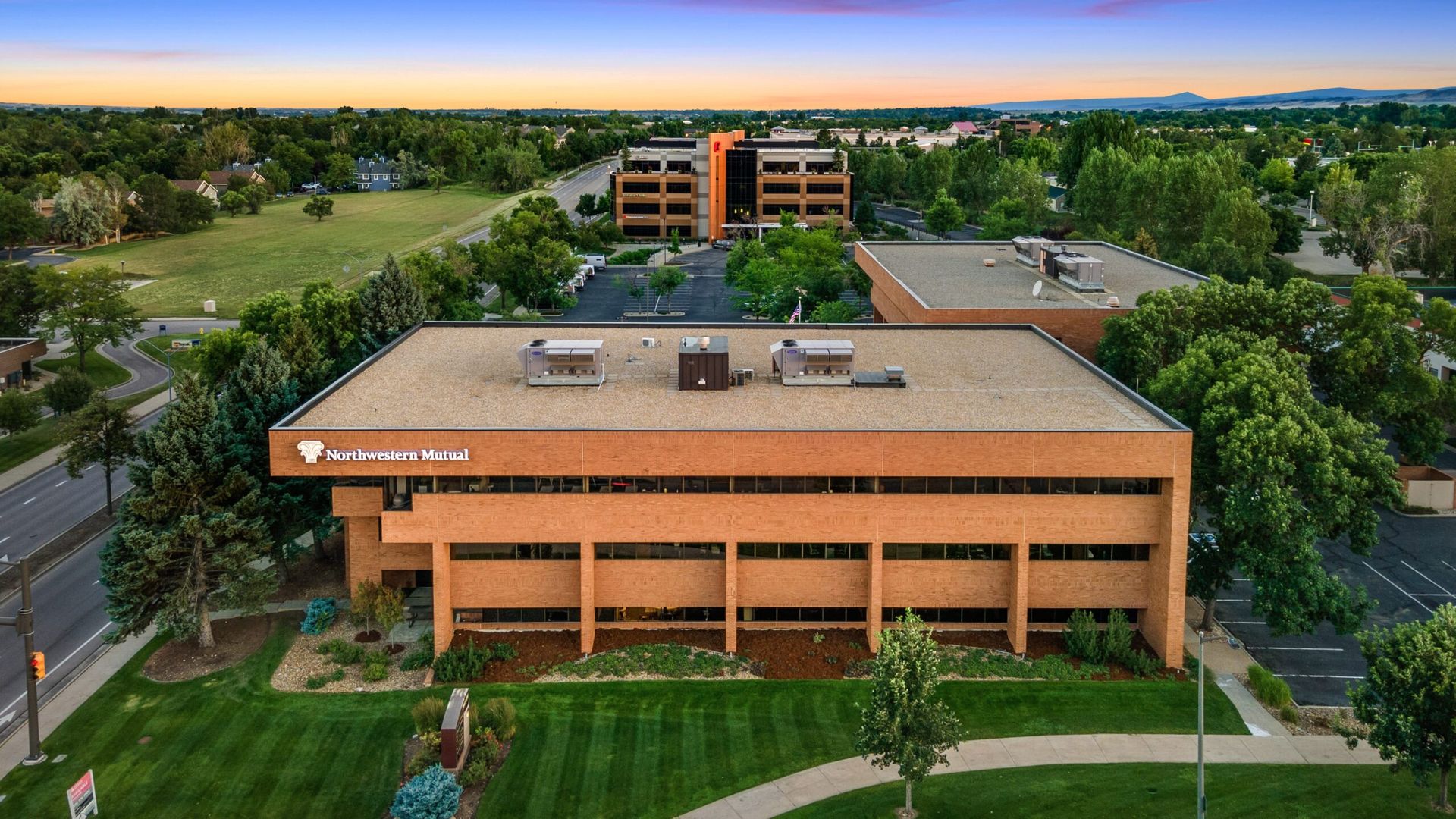 An aerial view of a large building surrounded by trees and grass.